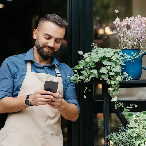 Man on his phone outside a plant shop