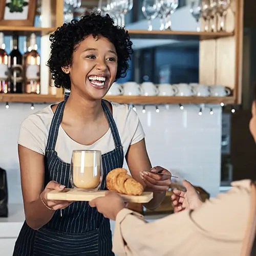 Woman in a coffee shop serving a customer