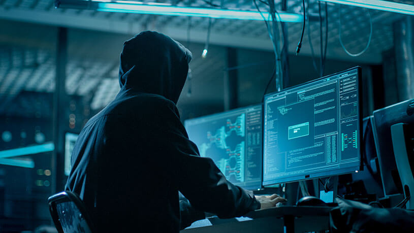 Hooded hacker breaking into corporate data servers.