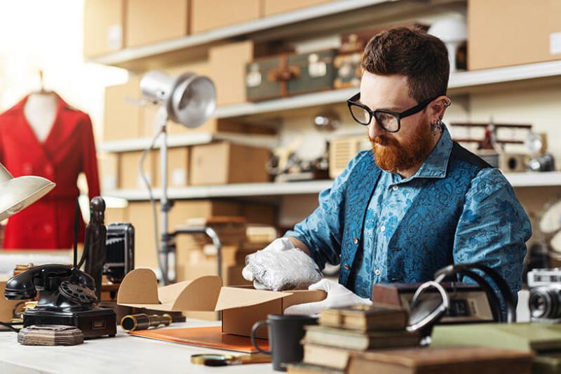 A small business owner packs orders for delivery