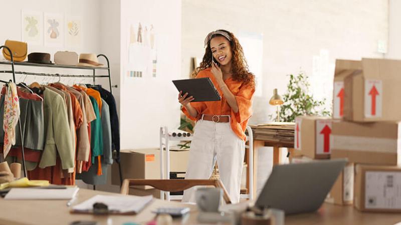 Small business owner on phone taking sales orders and checking inventory.