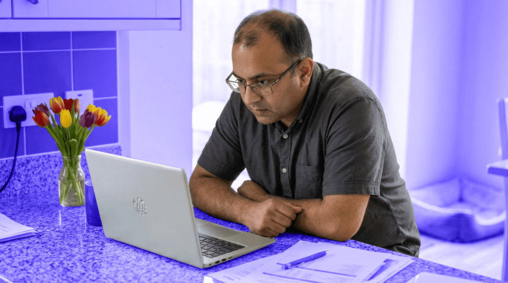 A male landlord works at his computer to work out his tax on rental income