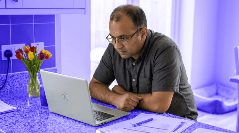 A male landlord works at his computer to work out his tax on rental income